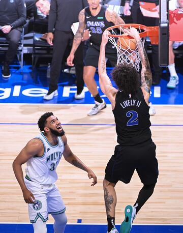 Dallas Mavericks center Dereck Lively II dunks as Minnesota Timberwolves center Karl-Anthony Towns looks on.